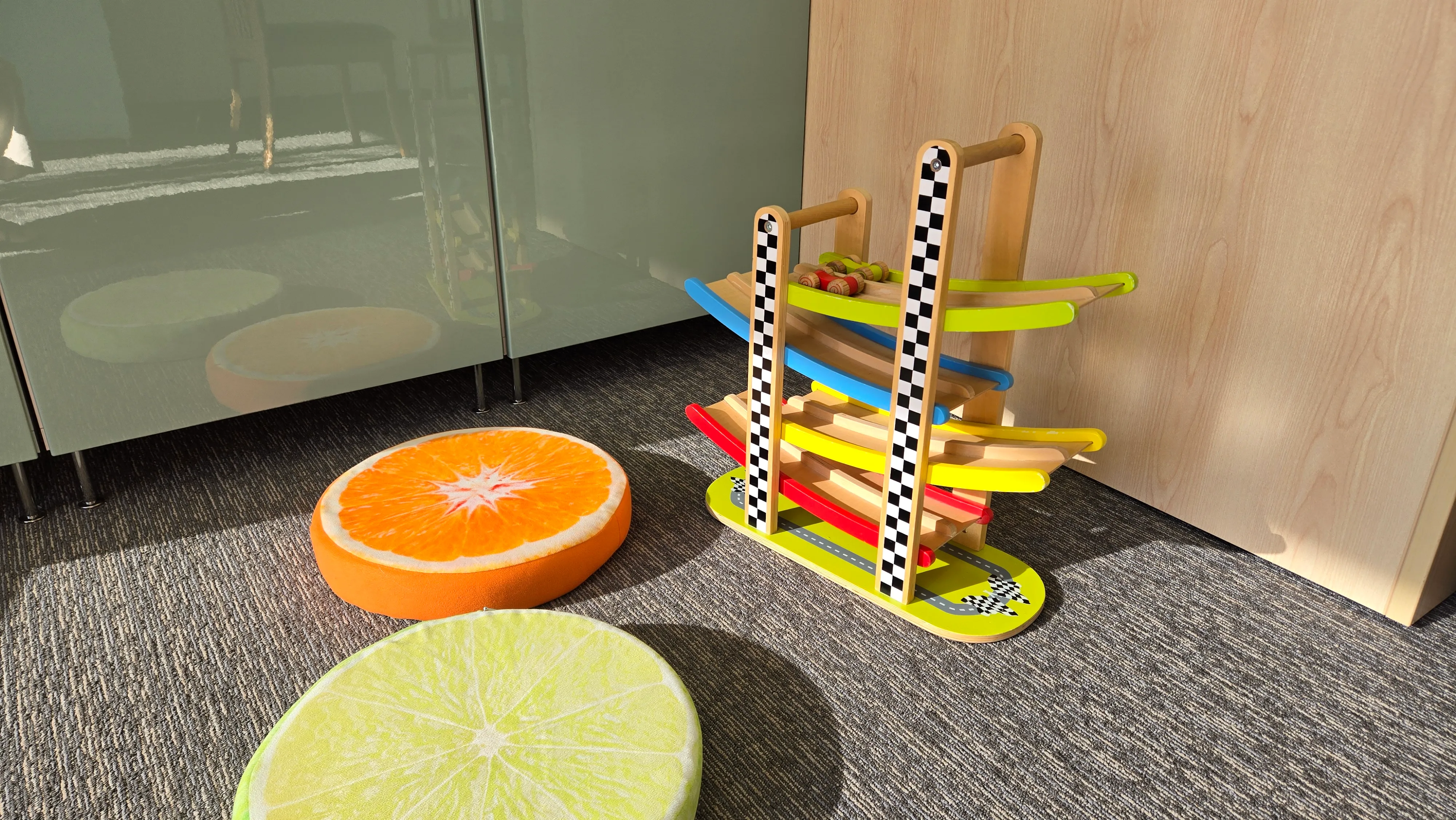 A wooden car ramp toy and cushions in the therapy room