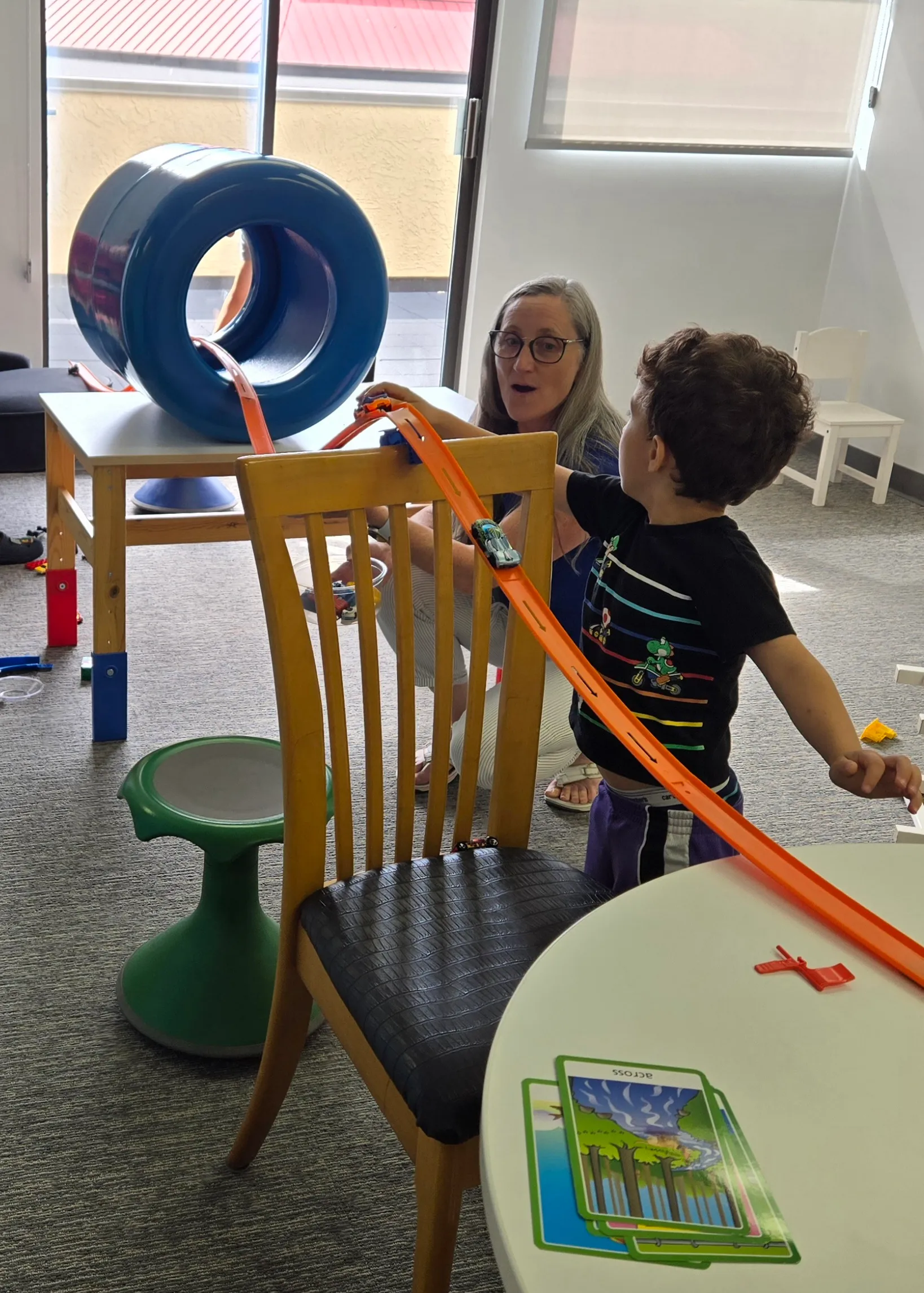 Heather building a hot wheels track with a patient.